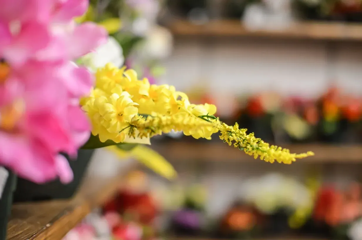 Gros plan sur des fleurs artificielles jaunes et roses en magasin