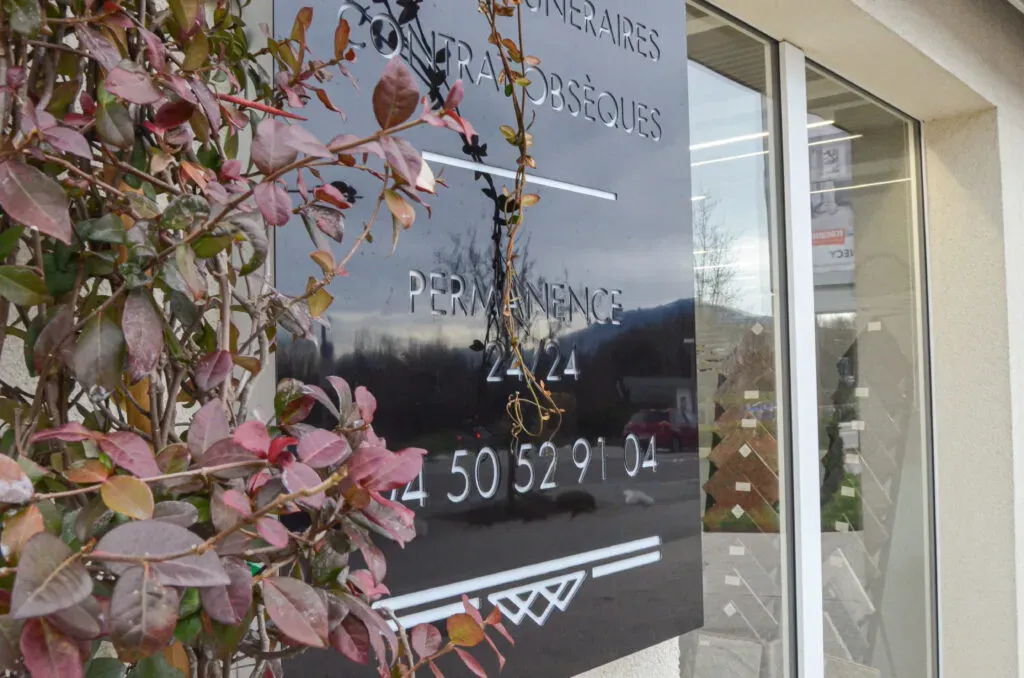 Plaque signalétique extérieure indiquant une permanence funéraire 24h/24